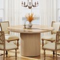 Ronde eettafel met houten visgraatblad en gecanneleerde poot, omringd door vier stoelen met linnen bekleding.