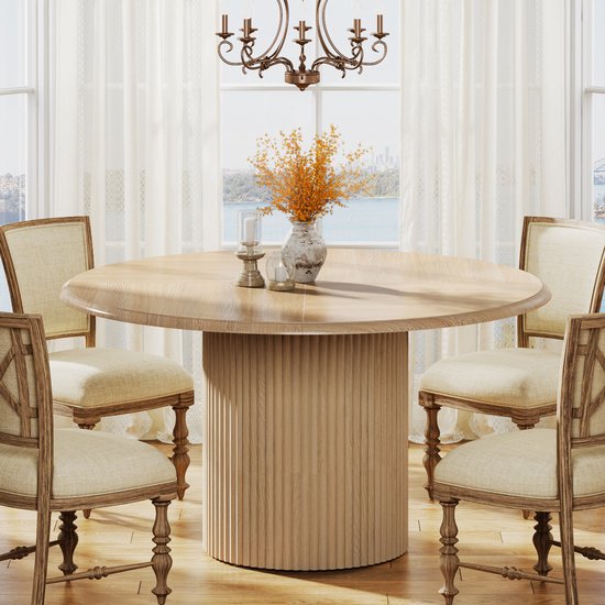 Ronde eettafel met houten visgraatblad en gecanneleerde poot, omringd door vier stoelen met linnen bekleding.