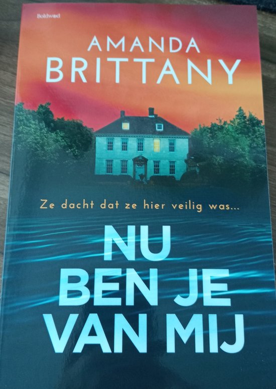 Boekcover met de titel "Nu ben je van mij". Een huis bij nacht met water op de voorgrond.