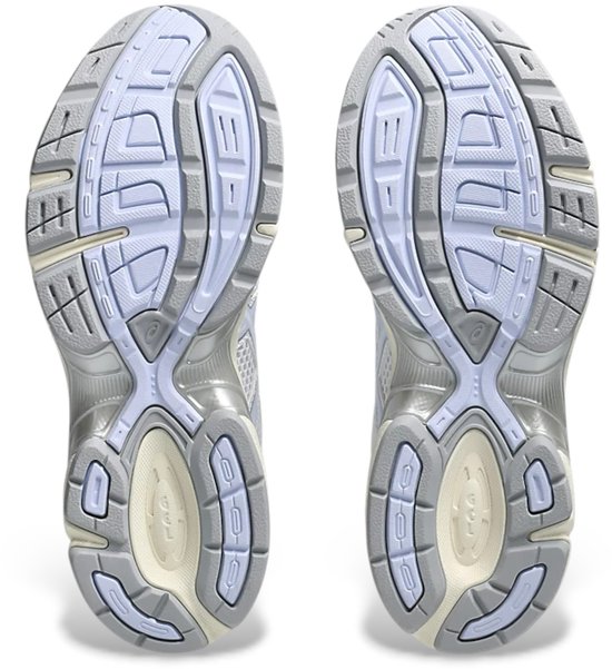 Onderkant van witte ASICS GEL-1130 sportschoenen met lichtblauwe en crèmekleurige accenten.