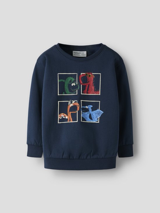 Donkerblauwe sweater met een print van vier dinosaurussen in vakjes. Een groene, een rode met zonnebril, een oranje en een blauwe.