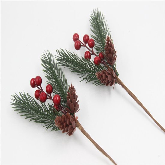 Twee kersttakken met groene naalden, rode bessen en bruine dennenappels.