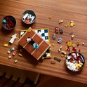 LEGO-bouwstukken en minifiguren van Harry Potter verspreid op een houten tafel.