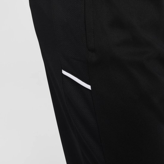 Detail van een zwarte Nike trainingsbroek met mesh-inzetstuk aan de zijkant en een witte streep.