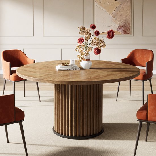 Ronde houten eettafel met gedetailleerd onderstel en oranje stoelen.