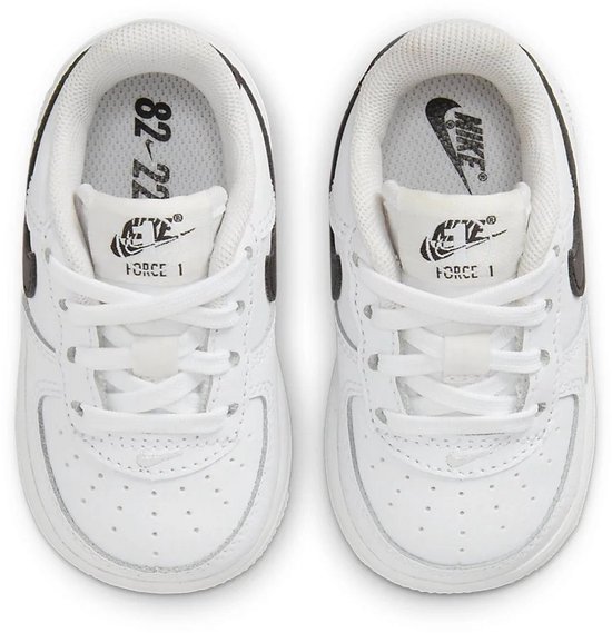 Witte Nike Air Force 1 sneakers voor peuters met zwarte Nike-logo's en '82-22' op de binnenzool.
