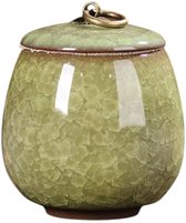 Lichtgroene keramische mini-urn met craquelé-patroon en gouden ring op deksel, geïsoleerd.