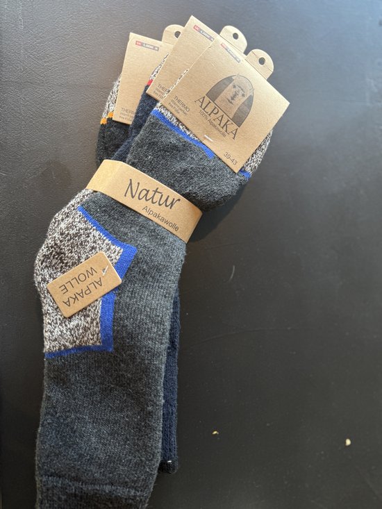 Grijs Alpaca sokken met blauwe en grijze accenten, maat 39-43. "Alpaka Wolle" label.