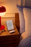 Witte Kobo afstandsbediening met twee knoppen, naast een e-reader op een nachtkastje.