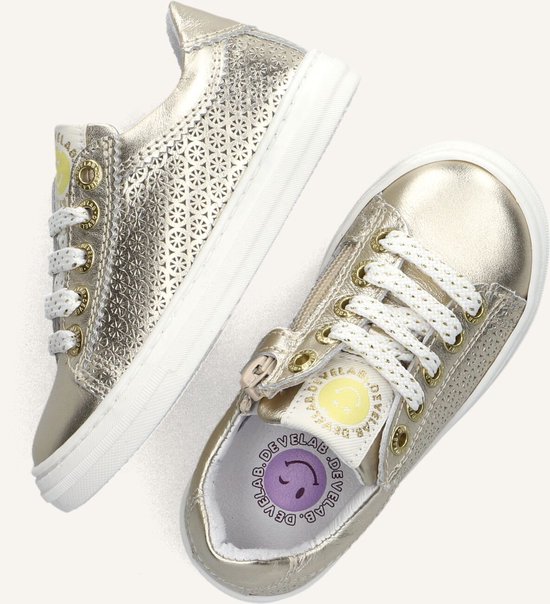Twee gouden leren sneakers met perforaties en witte veters.