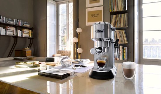 Zilverkleurig De'Longhi espressoapparaat op een glanzende tafel in een woonkamer, met een glaasje espresso en een glas cappuccino.