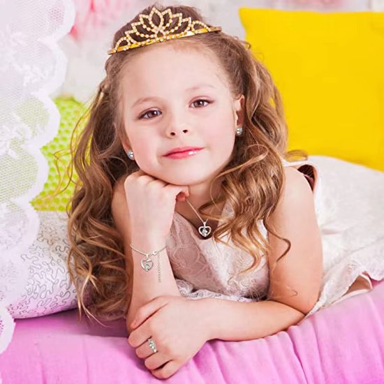 Meisje met tiara, draagt een zilverkleurige eenhoorn-set: ketting, oorbellen, armband en ring.