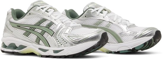Witte ASICS Gel-Kayano 14 sneakers met zilveren en groene details.