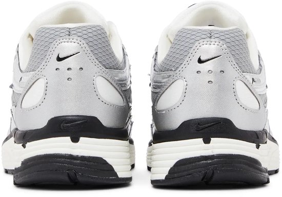 Achterkant van zilverkleurige Nike P-6000 sneakers met zwarte en witte details.