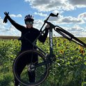 Vrouw met fiets in een zonnebloemenveld.
