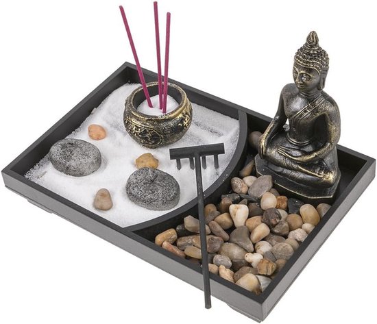 Zen tuin met Boeddhabeeld, wierookhouders met rode wierookstokjes, stenen en een harkje.
