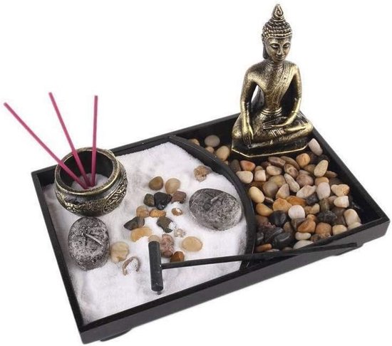 Zen tuin met Boeddhabeeld, wierookhouders met rode wierookstokjes, stenen en een harkje.