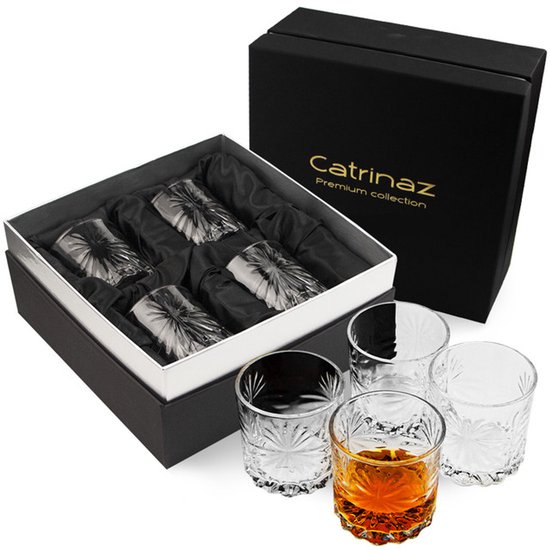 Ensemble de quatre verres à whisky Catrinaz dans une boîte cadeau. Quatre verres sont dans la boîte, trois sont à côté, dont un rempli de liqueur.