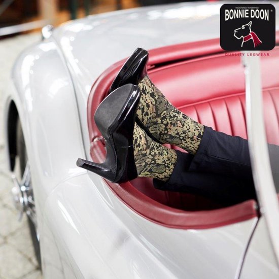 Voeten van een model in een auto met bruine kniekousen met bloemenpatroon.