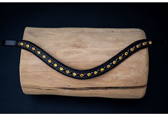 Zwarte frontriem met goudkleurige stenen op een houten blok.