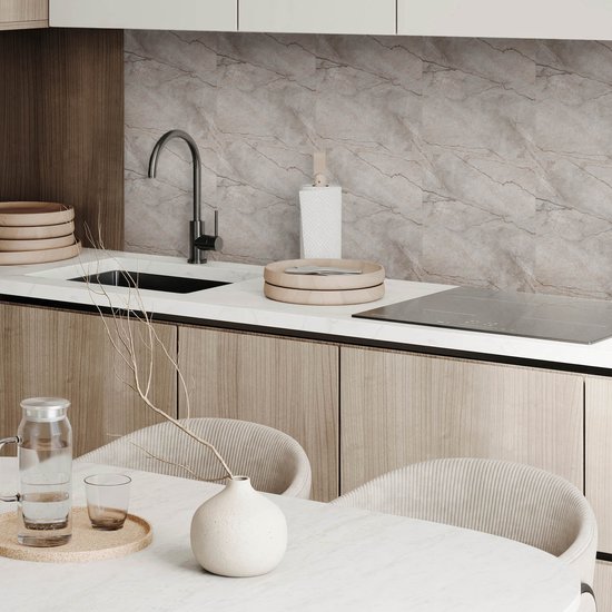 Keuken met grijze tegels met natuursteenpatroon achter het aanrecht en houten kasten.