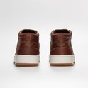 Achterkant van bruine leren mid-top sneakers met witte zolen.
