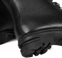 Detail van de zwarte leren kist, met grove stiksels en profielzool.