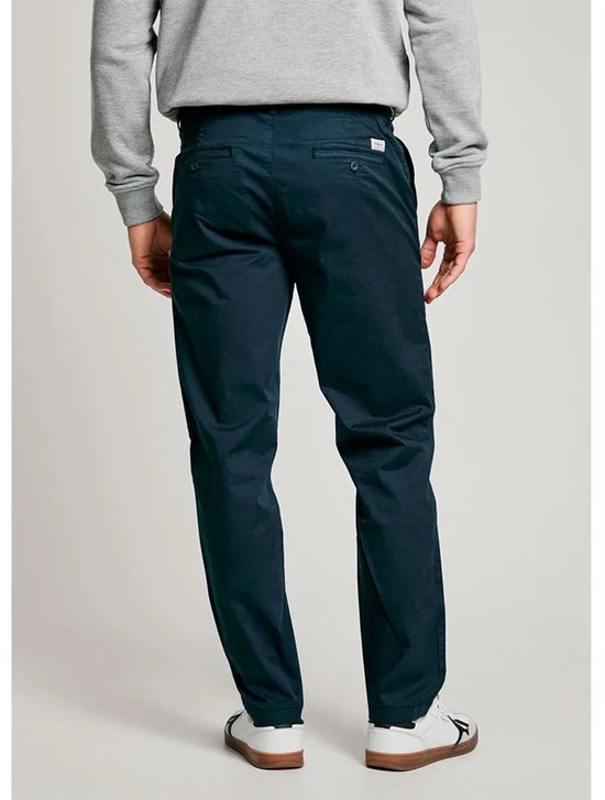 Achteraanzicht van donkerblauwe chino gedragen met grijze sweater.