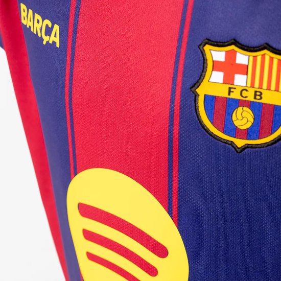 Barcelona voetbalshirt met rode en blauwe verticale strepen, het FCB-logo, de tekst "Barça" en een geel Spotify logo.