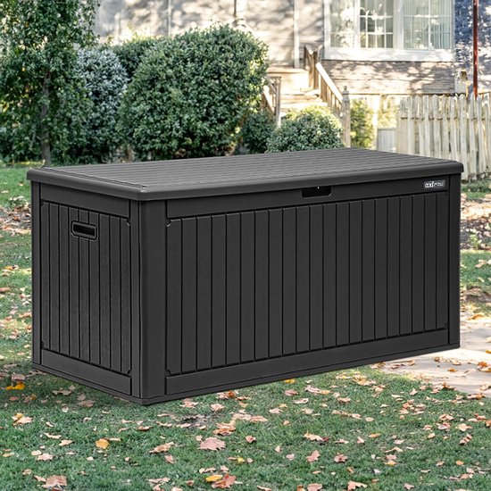 Zwarte kunststof tuinopbergbox met ribbelpatroon, geplaatst op een grasveld met herfstbladeren.