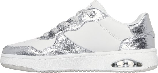 Zij-aanzicht van een witte Skechers sneaker met zilverkleurige metallic accenten en zichtbare luchtkussens in de zool.