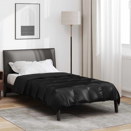 Zwart satijnen dekbed op een eenpersoonsbed, in een slaapkamer.