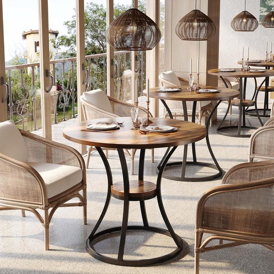 Bruine ronde tafel met houten blad, metalen onderstel, in een restaurantsetting met rieten stoelen.