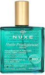 Groene Nuxe Huile Prodigieuse Néroli fles met gouden dop. De tekst op de fles is weerspiegeld.