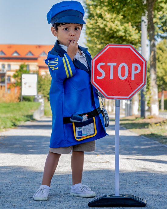 Jongen in blauw politie kostuum met STOP-bord, pet, handboeien en fluitje.