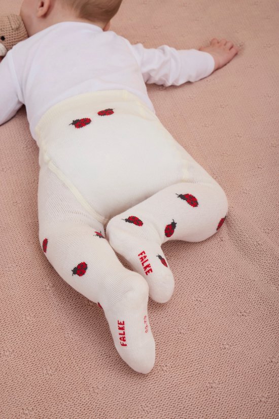 Baby in wit gebreide panty met rode lieveheersbeestjesprint en FALKE logo op de voet. Size 63-74.