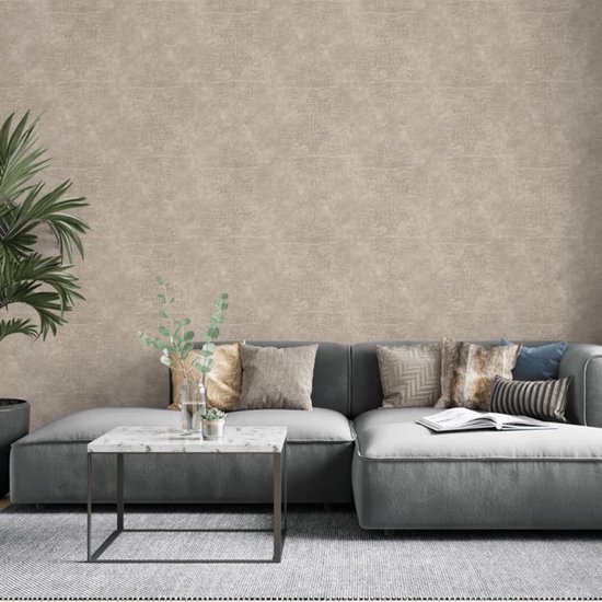 Beige behang met krokodillenleren textuur op een muur boven een grijze hoekbank met kussens.