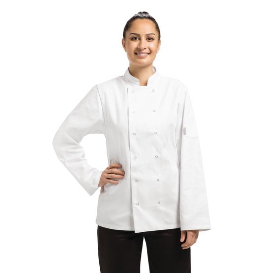 Vrouw in een witte koksbuis met lange mouwen en zwarte broek, hand op de heup.