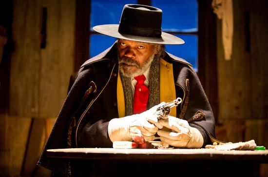 Samuel L. Jackson met rode das, zwarte jas en hoed, houdt een revolver vast. "The Hateful Eight".