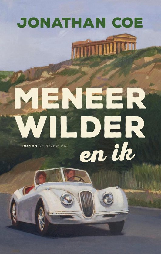 Boekcover met de titel "Meneer Wilder en ik" van Jonathan Coe. Een witte sportauto rijdt op een weg met op de achtergrond een oud gebouw op een heuvel.