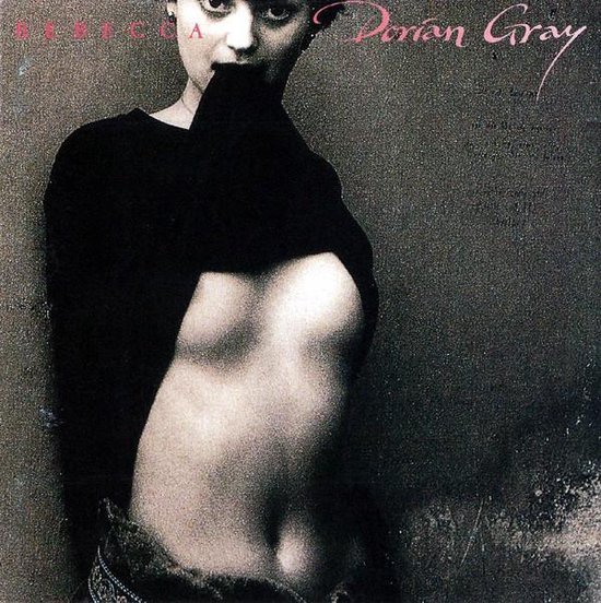 Een vrouw met een zwart kledingstuk omhoog gehouden, die haar borst onthult. REBECCA Dorian Gray.
