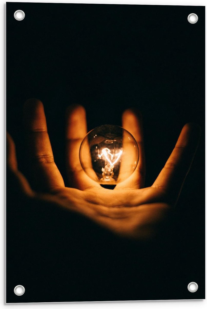 Tuinposter – Lichtgevende Gloeilamp in Handen met Zwarte Achtergrond - 40x60cm Foto op Tui