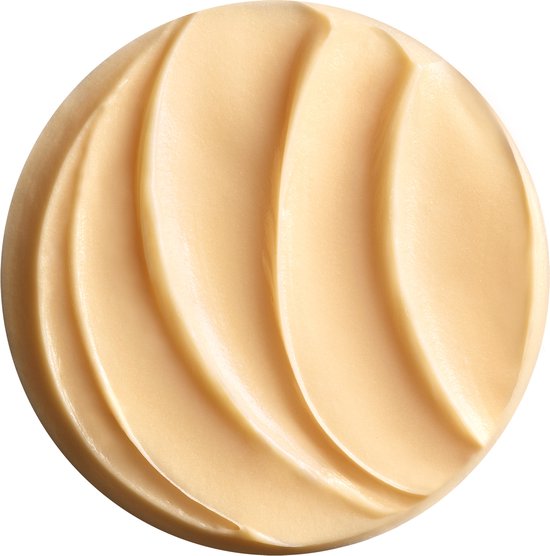 Een cirkelvormige veeg van goudkleurige nachtcrème met duidelijke ribbels.