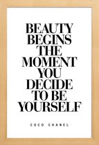 JUNIQE - Poster in houten lijst Beauty Begins - Coco Chanel quote
