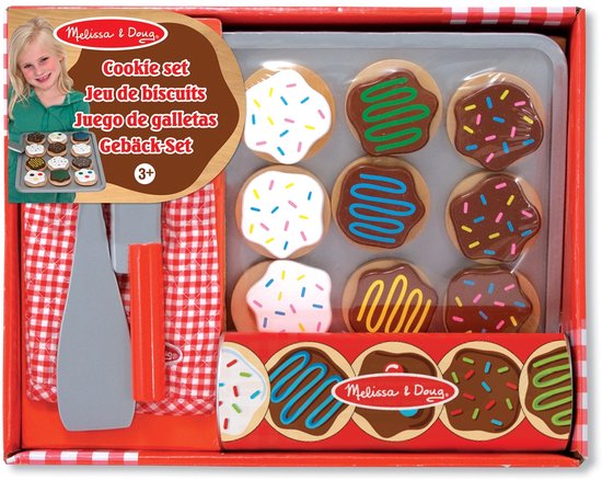 De verpakking van een koekjes speelset. Bevat houten koekjes, een bakplaat, ovenwant, spatel en mes. Een meisje staat op de voorkant.
