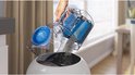 L'aspirateur Philips PowerPro Compact est vidé dans une poubelle blanche.