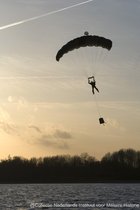 Schilderij Parachutist landing - Forex - Zonsondergang - 50 x 80 cm