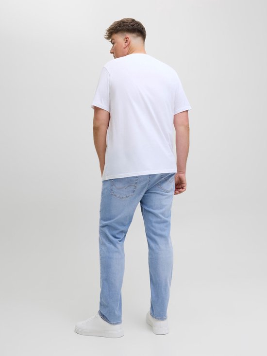 Man draagt een witte T-shirt en een lichtblauwe spijkerbroek met de achterkant naar de camera.