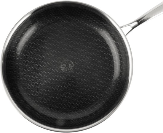 Zilverkleurige koekenpan met honingraatpatroon en metalen handvat, van bovenaf gezien.