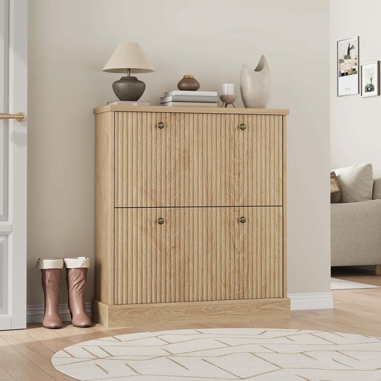 Meuble à chaussures en bois avec deux portes côtelées fermées et boutons dorés, à côté d'une porte et d'un tapis rond.
